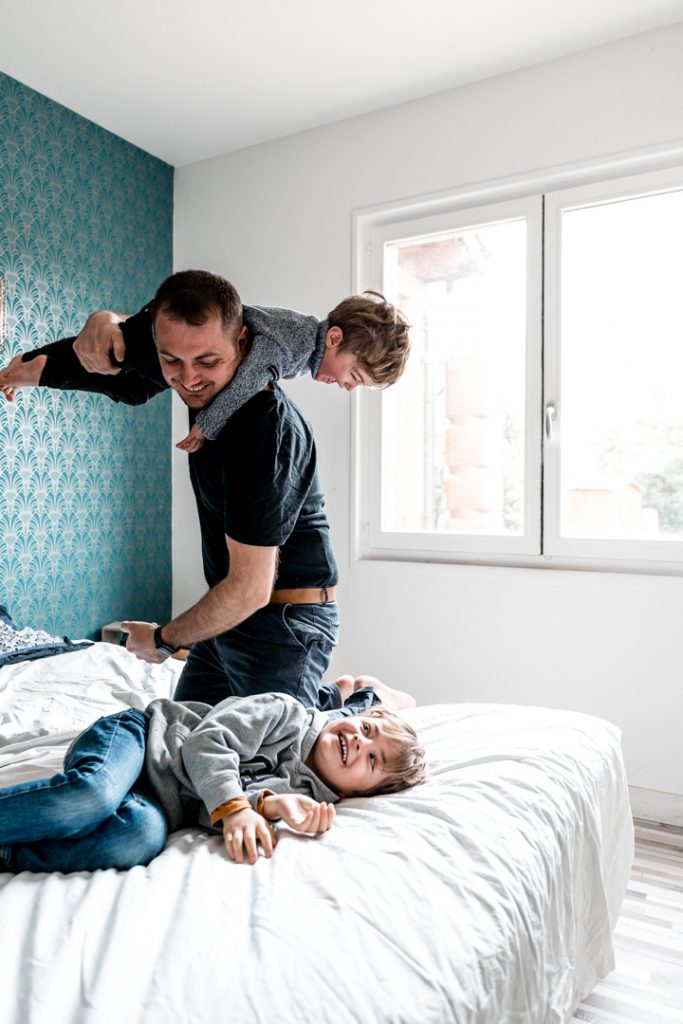Amelie Charlet photographe séance photo famille enfants et papa sur le lit