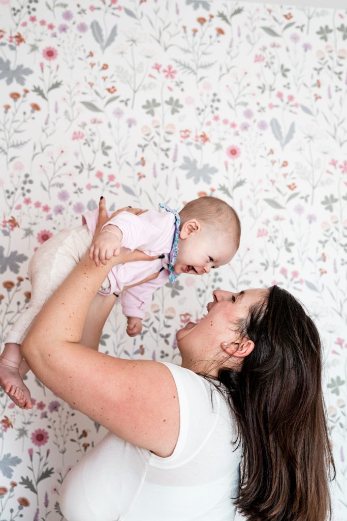 Amelie Charlet photographe séance photo naissance maman qui joue avec son bébé et qui rigole