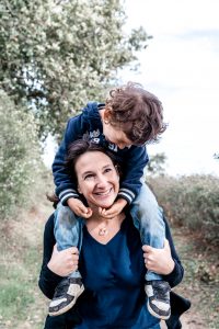 Amelie Charlet photographe séance photo famille Monts du lyonnais maman qui sourit e et porte son fils sur ses épaules