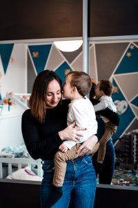 Amelie Charlet photographe seance photo famille Monts du lyonnais qui rigolent avec leur premier enfant maman qui écoute un secret de son fils