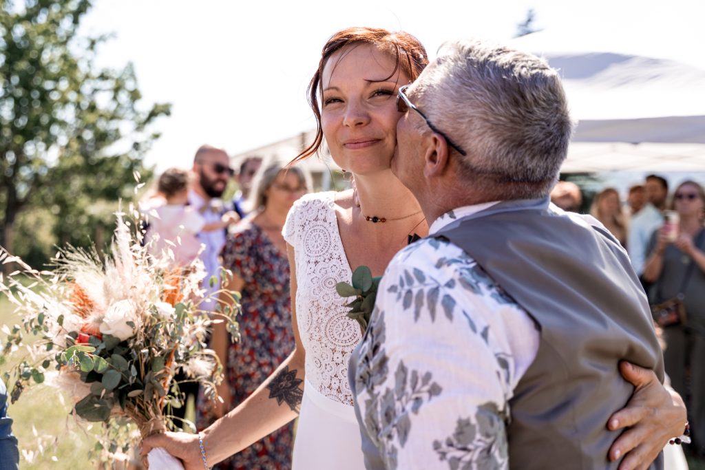Amelie Charlet photographe reportage photo mariage papa qui embrasse sa fille à la cérémonie de mariage
